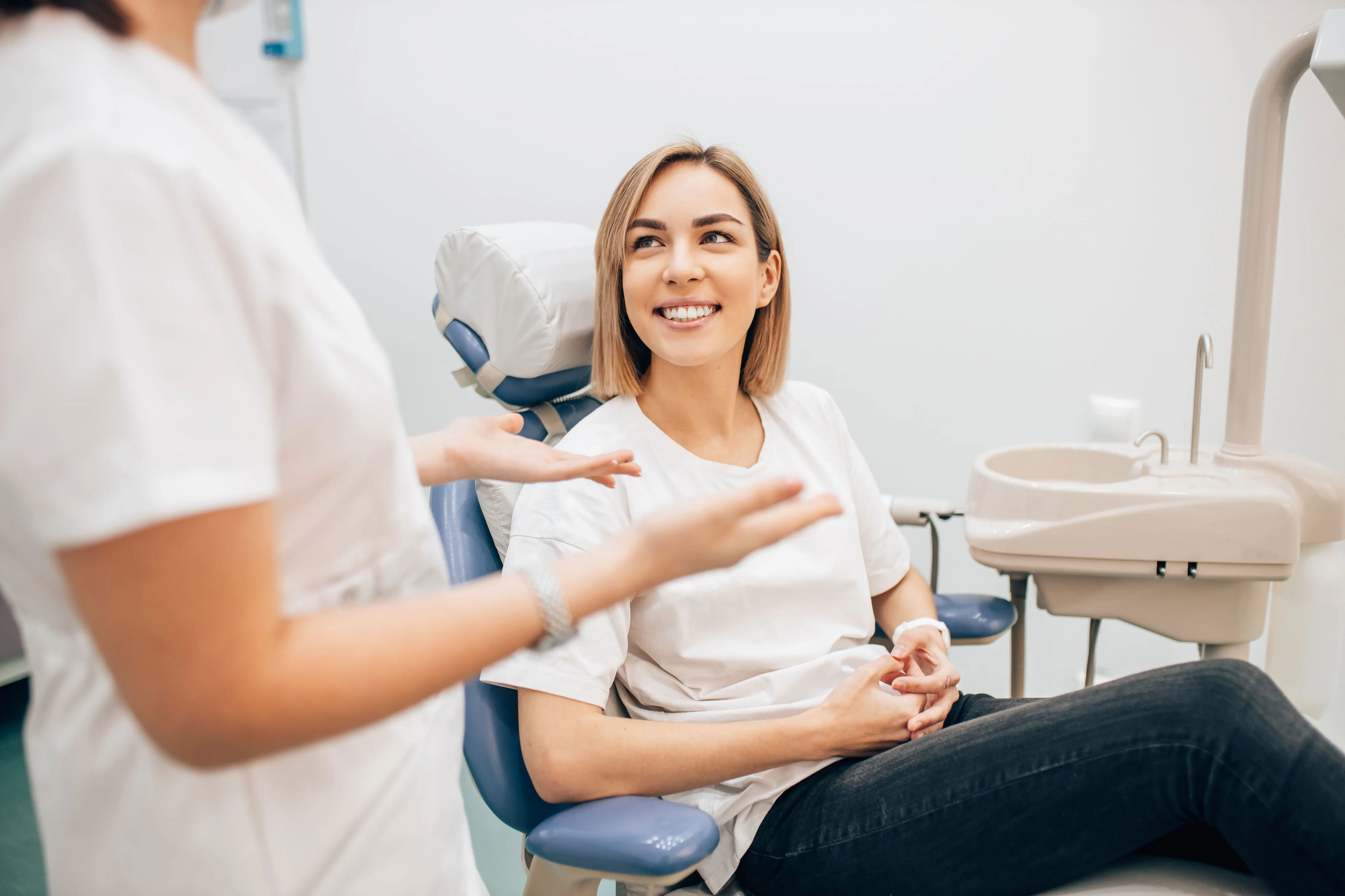 A smiling patient in a dental chair during a consultation