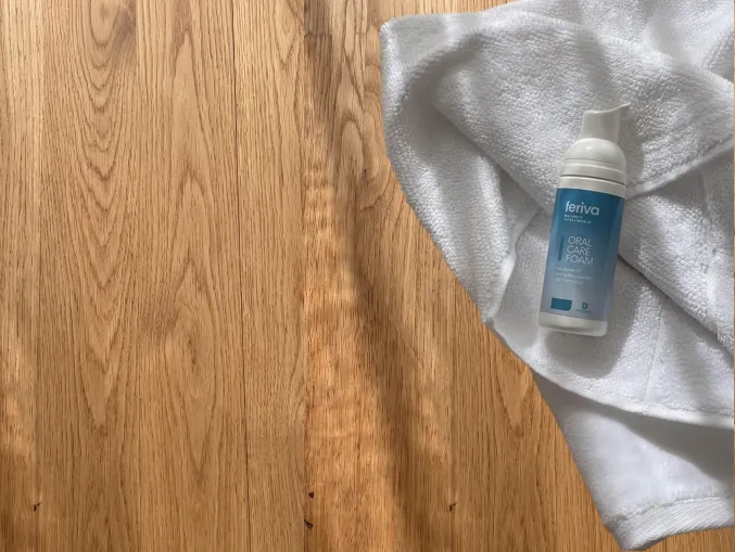 Feriva Oral Care Foam resting on a folded white towel on a wooden table